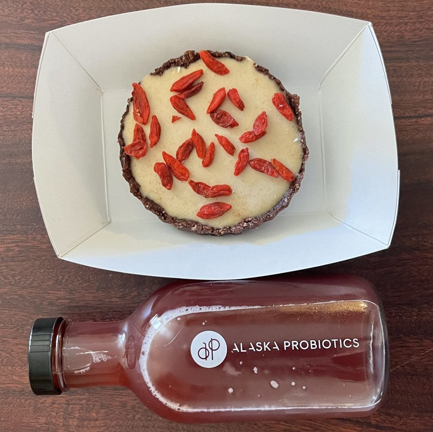 A bottle of kombucha from Alaska Probiotics and a vegan berry tart in a to-go container
