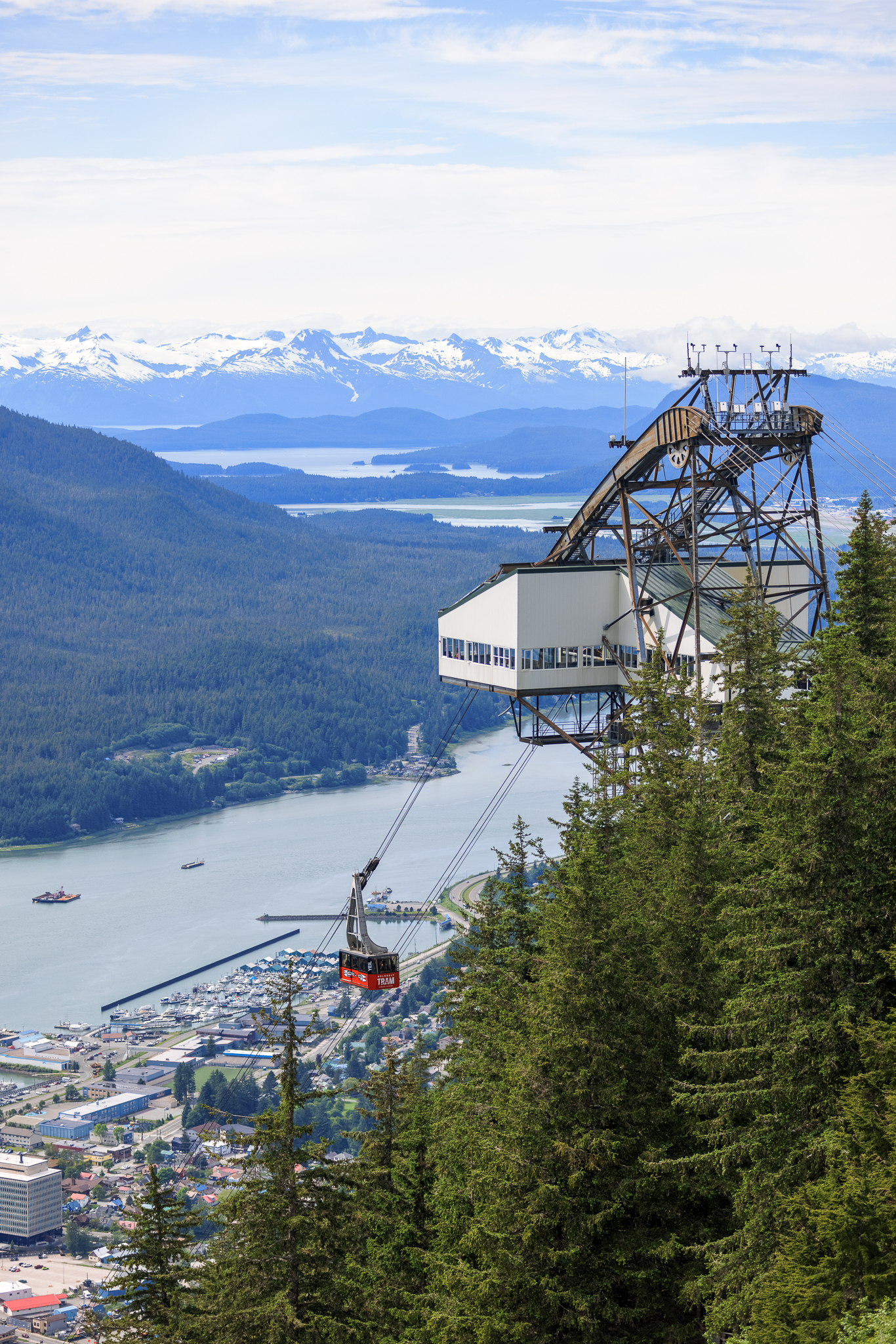 View of the Goldbelt Tram with downtown Juneau and snow capped mountains in the background.