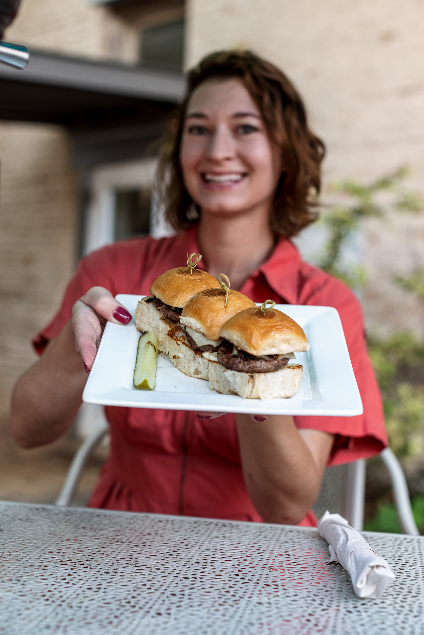 Woman holding a plate of lamb sliders in Boerne, TX.